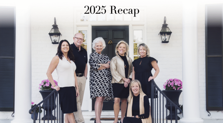 Landfall Realty team standing in front of a white brick home during the 2025 year-in-review photo.